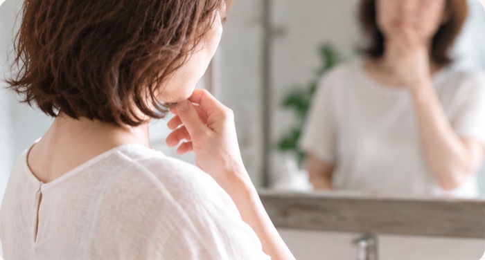鏡を見て悩む女性